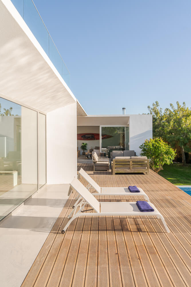 Contemporary terrace with timber decking beside a narrow pool