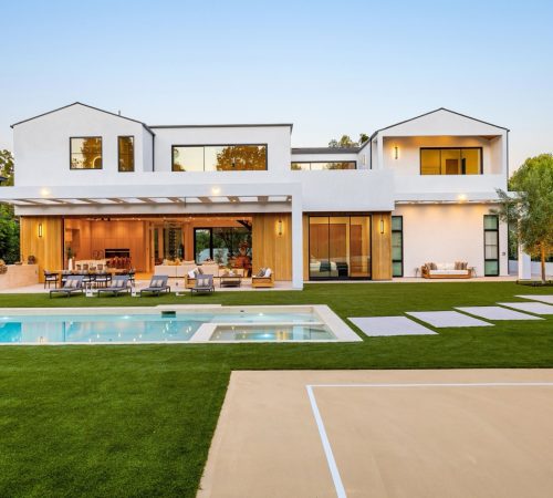 Modern luxury home with pool and patio in a serene suburban setting at sunset, showcasing contemporary architecture and outdoor living space.